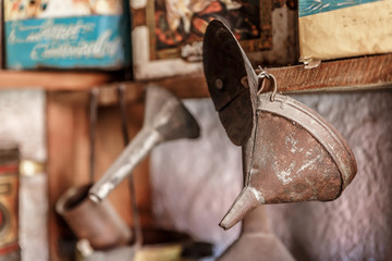 Foreground of an old funnels hanging on the shelf of a kitchen