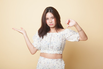 Young Asian woman show palm hand and thumbs down.