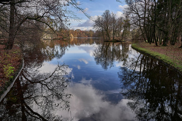 A lake in autumn with reflections of a blue sky, Badenburger See, Nyphenburg park, Munich, Germany