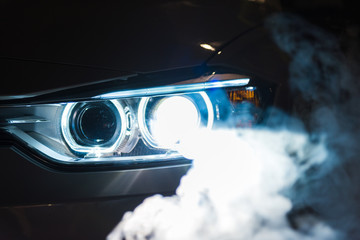 Luxury modern sport car headlights with smoke.