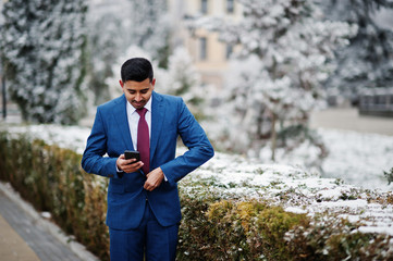 Elegant indian fashionable man model on suit posed at winter day.