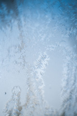 Frosty patterns on the frozen window are macro. Winter background