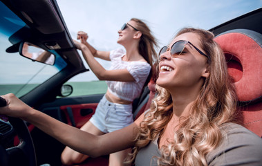 close up.cheerful young women traveling in a convertible