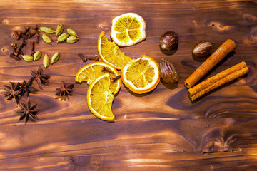Mulled wine in rustic mug with spices and ingredients on wooden background. Top view, flat lay. Retro toned photo. Copy space for your text.