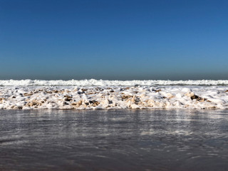 Waves foam on the sea shore coastline beach 