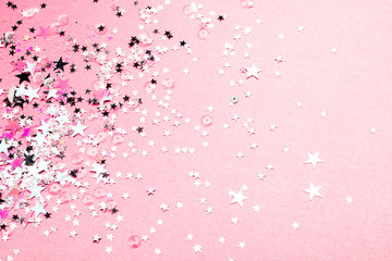 Silver star glitter on pink pastel background. Festive concept. Place for design.