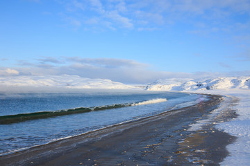 Arctic Ocean, winter time, snow shore, Russia, landscape of beautiful wild nature of north sees. Beautiful snow winter ice and cold landscape, picturesque view with mountains on horizon, sky clouds