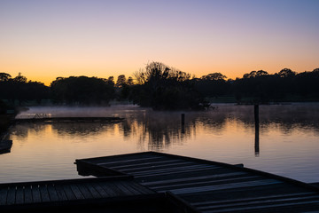 Jetty and mist on a lake at dawn
