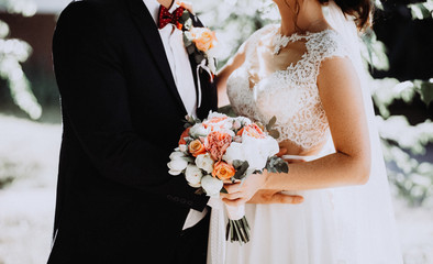 Bride, holding a wedding bouquet of flowers . Wedding gold rings. Bridal wedding dress. Hand of a...