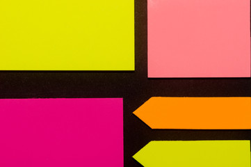 Purple, yellow, orange and rose hue colorful office stickers on black paper. Office noteparer as...