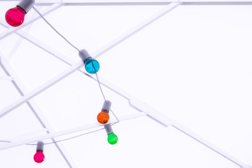 Garland of multi-colored light bulbs hanging on a metal structure.