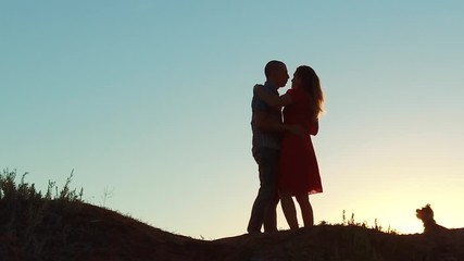 silhouette of a happy young married couple and dog slow dancing outside at sunset. slow motion video. man and girl dancing salsa at sunset. Unidentifiable Silhouette of dancing couple love lifestyle - Powered by Adobe