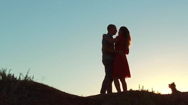 silhouette of a happy young married couple and dog slow dancing outside at sunset. slow motion video. man and girl dancing salsa at sunset. Unidentifiable Silhouette of dancing couple love lifestyle
