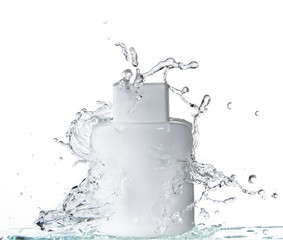 Naklejka na ściany i meble White square glass bottle on white background and splashing water