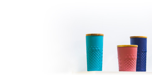 Ceramic color mugs with a lid for coffee on white background