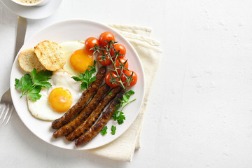 Fried eggs, sausages and cherry tomatoes