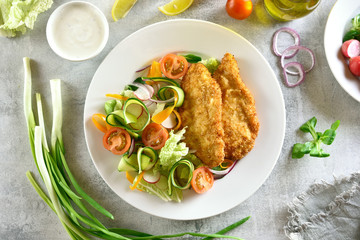Vegetable salad and breaded chicken breast