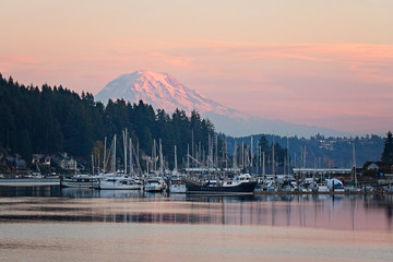 mt rainier in seen in the little town of gig harbor in washington state, boats and ships in the harbor frame the mountain 