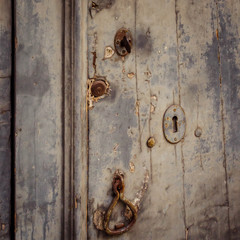 Close up of a door with three ancient locks and an old knocker