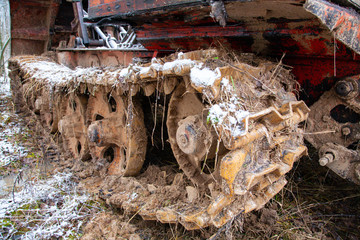 track closeup of Rusty abandoned caterpillar snow tractor on winter surrounding, russia