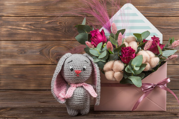Arrangement in an envelope of flowers in soft pink with cotton, Crochet toy hare