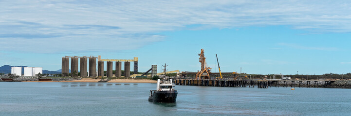 Tug Boat At Harbor With Export Infrastructure