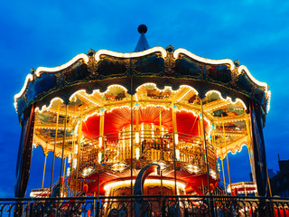 Carousel at an amusement park in the evening and night illumination