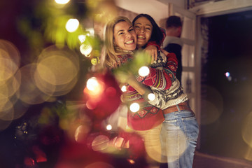 female friends hugging and celebrating Christmas.