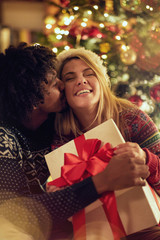 Fototapeta na wymiar Romantic male and female exchanging Christmas presents.