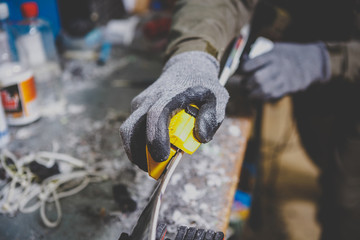 Male worker repairing Stone, edge sharpening in ski service workshop, sliding surface of the skis. sharpening of an edging of a mountain skis by means of the individual tool. Theme repair of ski curb