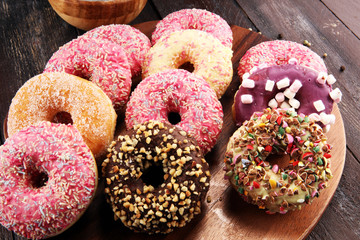 assorted donuts with chocolate frosted, pink glazed and sprinkles donuts