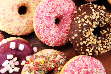 assorted donuts with chocolate frosted, pink glazed and sprinkles donuts