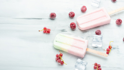 Popsicles on a stick. Bright color, summer mood. Eskimo berry with berries and ice on a light background. Flat-lay