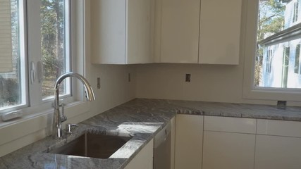 Repair man In Overalls Repairing Cabinet Hinge In Kitchen Installation of kitchen. Worker installs doors to kitchen cabinet.