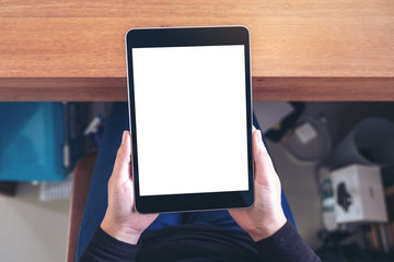 Top view mockup image of a woman holding black tablet pc with blank white screen while sitting on a chair