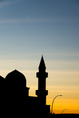 Silhouette of mosque minaret in city downtown