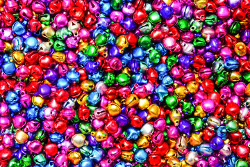 stack of mixed small colorful bells textured background (selective focus)