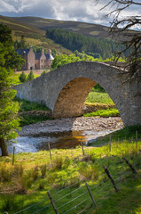 Fototapeta na wymiar Stone Bridge over Creek with Estate in Scotland