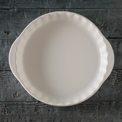 Large wooden bowl on dark wooden rustic table. The view from the top.