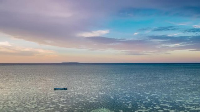 Time lapse tropical beach and sea at sunset. Colorful dramatic sky at dusk. Romantic passion concept. Tomia Island, Wakatobi national park, Indonesia.