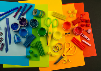 School accessories are laid out in the form of a rainbow. Black background.