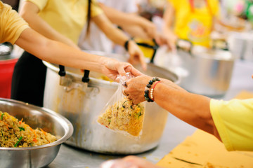 Donating food to beggars to alleviate hunger : the concept of sharing help to fellow human beings in society.