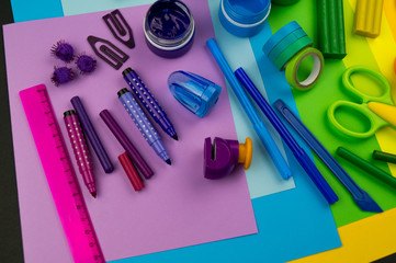 School accessories are laid out in the form of a rainbow. Black background.
