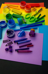 School accessories are laid out in the form of a rainbow. Black background.