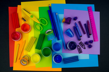 School accessories are laid out in the form of a rainbow. Black background.