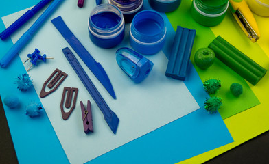 School accessories are laid out in the form of a rainbow. Black background.