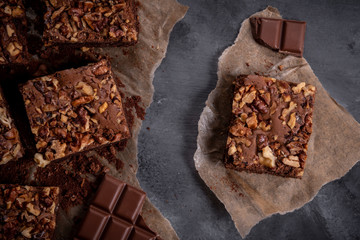 Sliced brownie cake on baking paper and chunks of chocolate