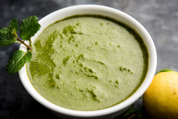 Healthy Green Mint Chutney Made with Coriander, pudina And Spices. isolated moody background. selective focus