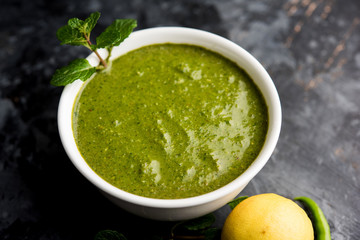 Healthy Green Mint Chutney Made with Coriander, pudina And Spices. isolated moody background. selective focus