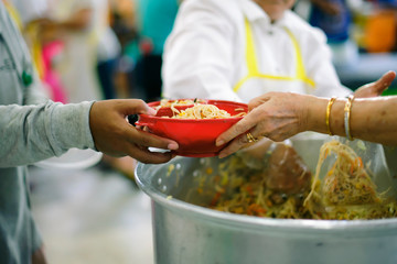 Homeless people are helped with food relief, famine relief : a social concept of sharing.